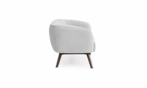 Vista lateral del Sofá Kaira de Aristas. Este sofá presenta un diseño de líneas limpias y elegantes, con tapizado en tela de tono neutro, y patas en madera color Chocolate.