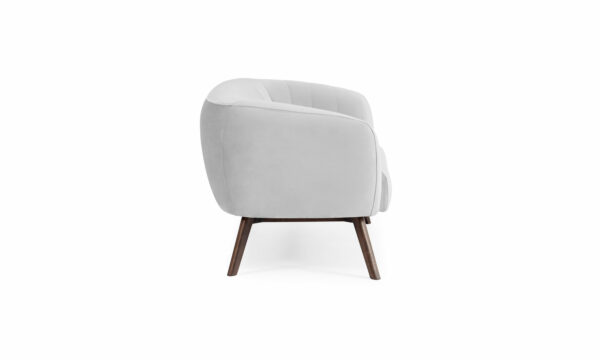 Vista lateral del Sofá Kaira de Aristas. Este sofá presenta un diseño de líneas limpias y elegantes, con tapizado en tela de tono neutro, y patas en madera color Chocolate.