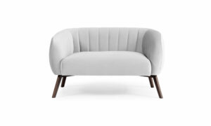 Vista frontal del Sofá Kaira de Aristas. Un diseño de líneas limpias y elegantes, con un tapizado en tela de tono neutro y un asiento acolchado.