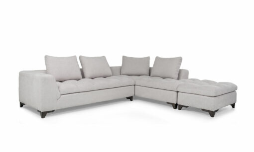 Vista diagonal del Modular con Puff Vitaro Plus Plumas de Aristas. Un diseño moderno con un tapizado suave y elegante, su asiento es acolchado y sus patas discretas en madera color Ceniza. El puff tiene el mismo estilo del sofá y complementa el conjunto.