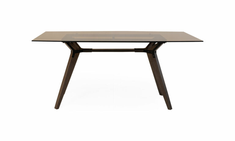 Mesa Comedor Atalanta Vidrio 6 Puestos de la marca Aristas vista en perspectiva frontal. El diseño presenta una estructura moderna con una superficie de vidrio transparente rectangular, sostenida por una base robusta de madera color Ceniza.