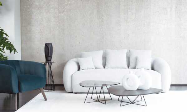Vista frontal del Sofá Demand de la marca Aristas. Presenta un diseño moderno y minimalista, con un tapizado en tela de tono neutro. Sus líneas limpias, cojines acolchados y reposabrazos ofrecen un aspecto elegante y acogedor.
