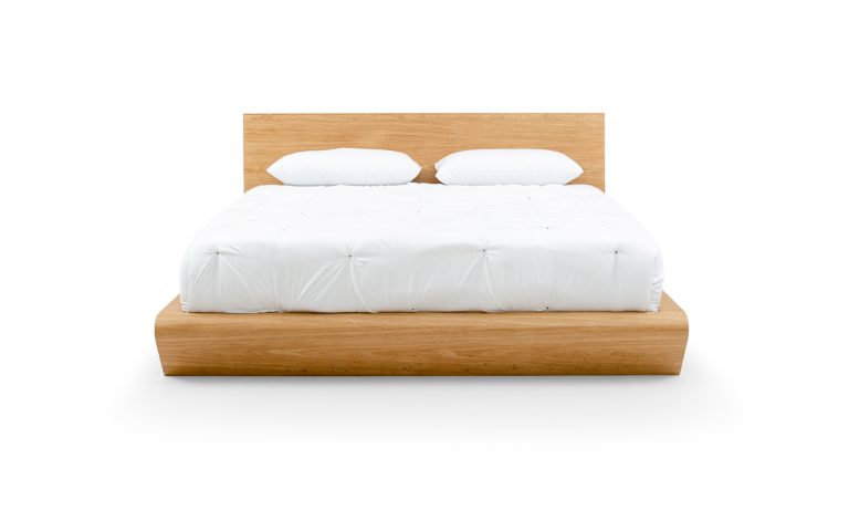 Vista frontal de la Cama Ese de Aristas. Un diseño minimalista que presenta una estructura con un espaldar amplio en madera color Escandinavo.