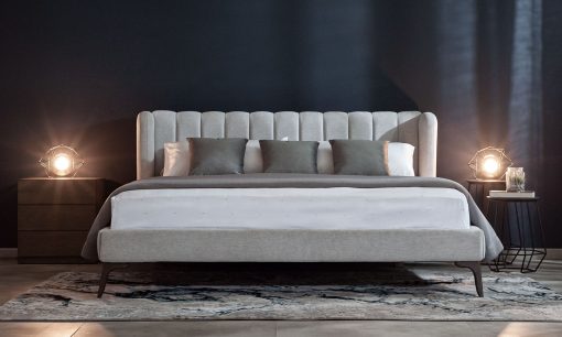 Cama Florencia de la marca Aristas vista en perspectiva frontal. Un diseño elegante con un cabecero alto, acabado en tela suave y patas delgadas en madera.