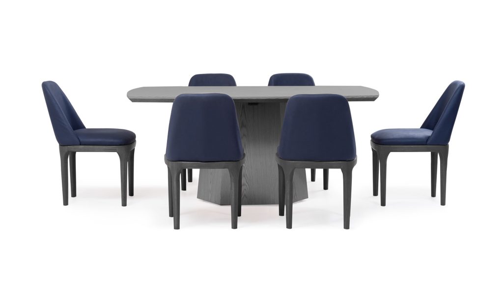 Mesa Comedor Milano con 6 Sillas Lisboa de la marca Aristas, vista en perspectiva frontal. La mesa presenta un diseño elegante en madera color Ceniza. Mientras, las sillas Lisboa presentan líneas suaves, respaldos curvos y un tapizado en el tono Tomasso Azul Profundo.