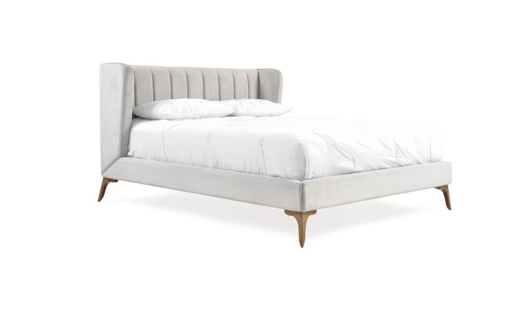 Cama Florencia de la marca Aristas vista en perspectiva diagonal. Un diseño elegante de líneas limpias, con un cabecero alto, un acabado en tela suave y patas delicadas en madera.