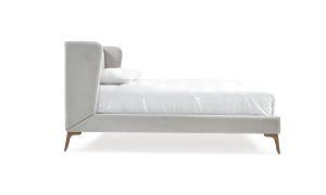 Cama Florencia de la marca Aristas vista en perspectiva lateral. Un diseño elegante, con un cabecero alto y un acabado en tela suave.
