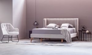 Cama Florencia de la marca Aristas vista en perspectiva diagonal. Un diseño elegante que destaca por su cabecero alto y acolchado de líneas limpias.