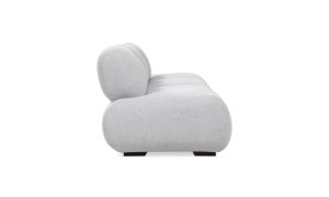 Sofá Modular Emma de la marca Aristas visto en perspectiva lateral. Un diseño moderno y elegante de líneas curvas, con un asiento y espaldar acolchado, tapizado en tela suave de color neutro.