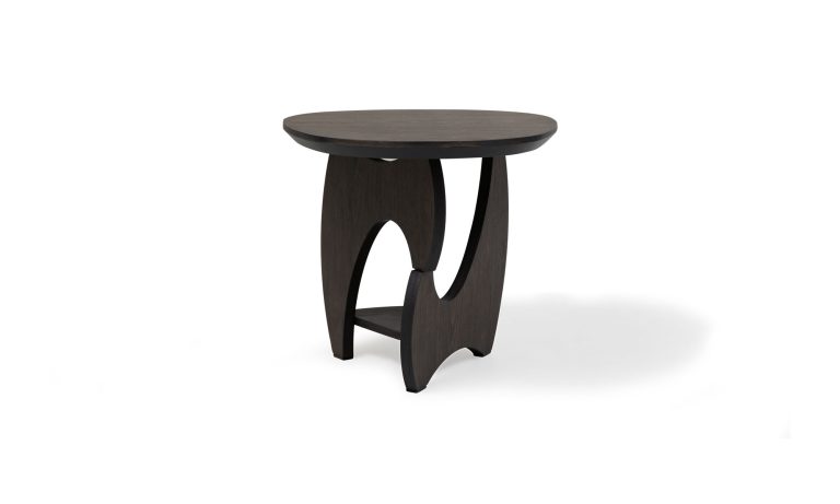 Vista diagonal de la Mesa Auxiliar Chelsea de la marca Aristas. Un diseño elegante y compacto en madera color Ceniza, con una supericie redonda y una base asimétrica.