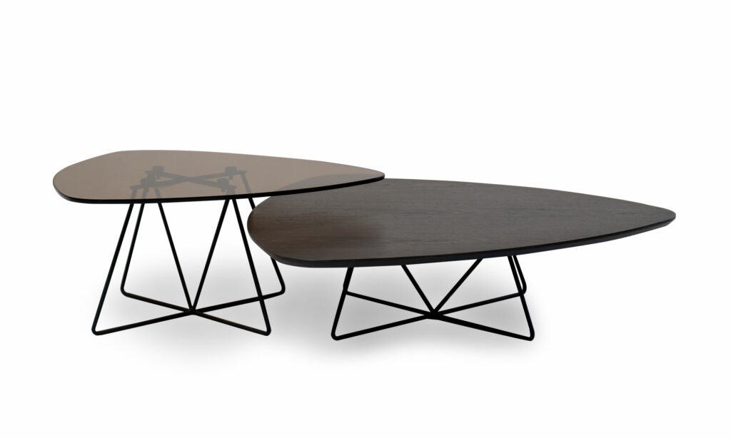 Vista lateral de las Mesas de Centro Boon Vidrio Madera x2 de Aristas. Este conjunto combina un diseño moderno y elegante en vidrio y roble europeo. Una mesa tiene una tapa de vidrio oscuro, y la otra presenta una superficie en madera color Ceniza. Ambas sostenidas por patas delgadas y metálicas que les dan un toque contemporáneo.