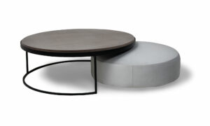 Juego de Mesa Centro Luna Mad 90 y Puff Luna 70 de la marca Aristas vista lateral. El conjunto presenta un diseño moderno y elegante, con formas redondeadas y acabados suaves. La mesa tiene una estructura robusta y minimalista, mientras que el puff complementa el conjunto con una estética igualmente sencilla y armónica.