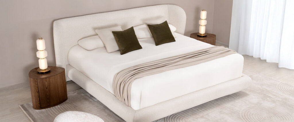 Dormitorio con cama de espaldar curvo en bouclé, cojines verde oliva y mesas de noche redondas en nogal
