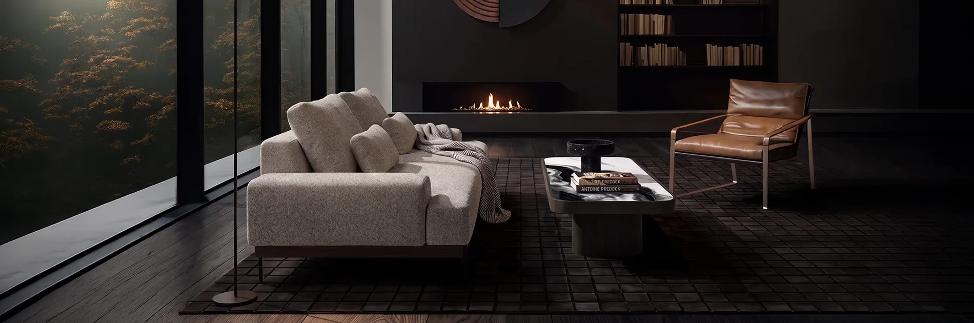 Sala en penumbra con sofá gris frente a una chimenea encendida, sillón en cuero y mesa de centro baja, con ventanal hacia el bosque