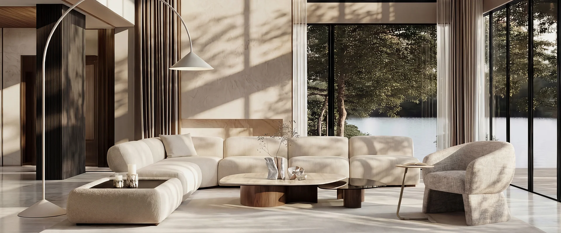 Sala de estar minimalista en tonos beige con sofá modular, mesas de centro redondas y vista al lago entre árboles