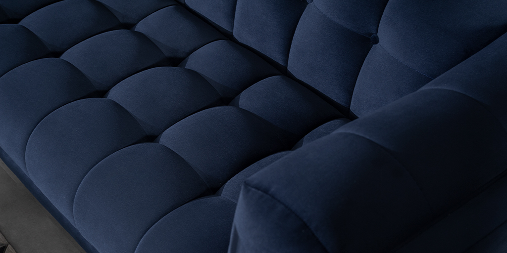 Detalle de la tapicería capitonada de un sofá azul oscuro